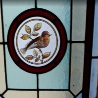Close up of stained glass window with robin design Close up of stained glass window with robin design