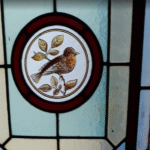 close up of stained glass window with robin design